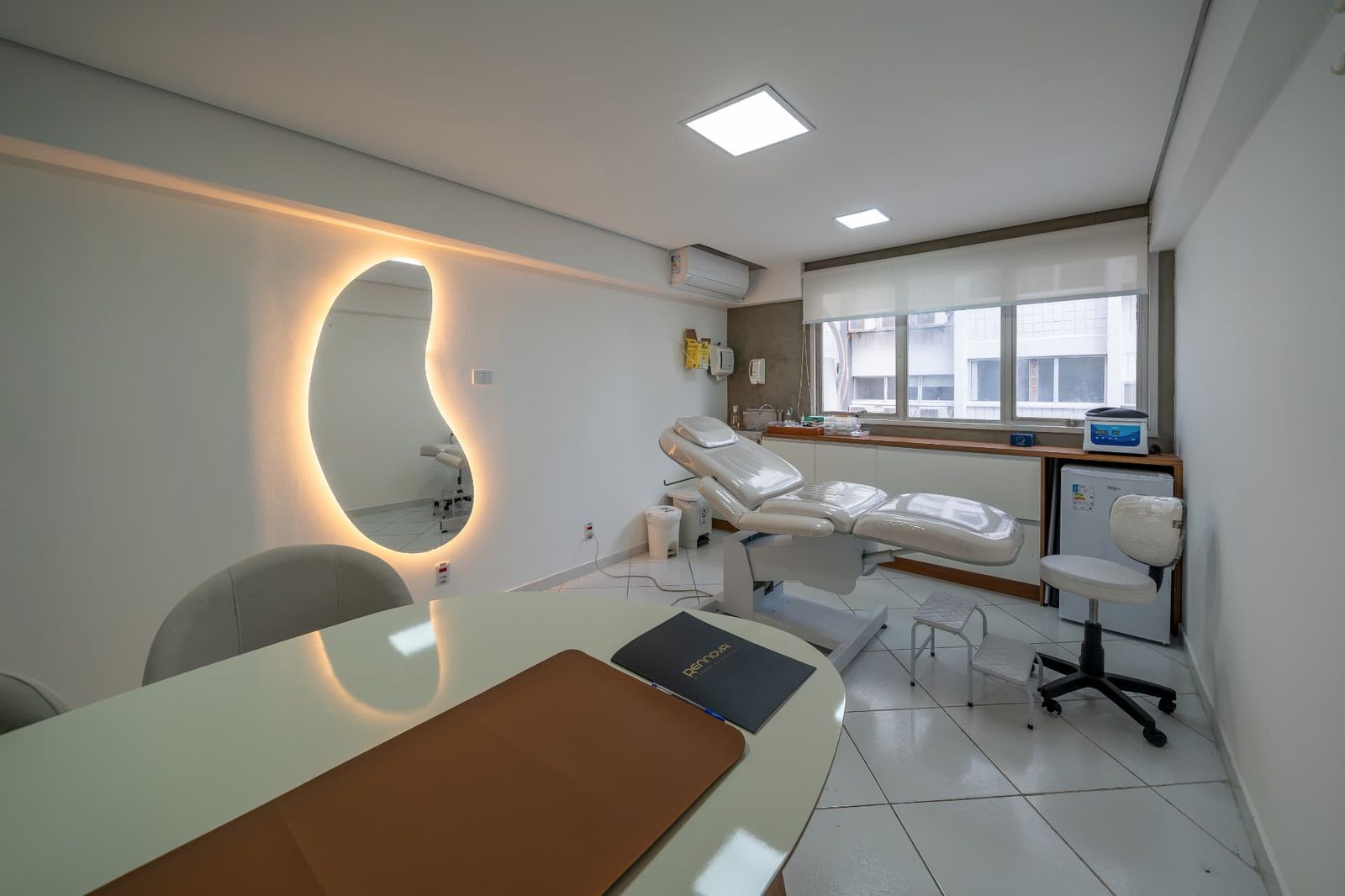 Consultório com maca elétrica, pia e espelho iluminado
