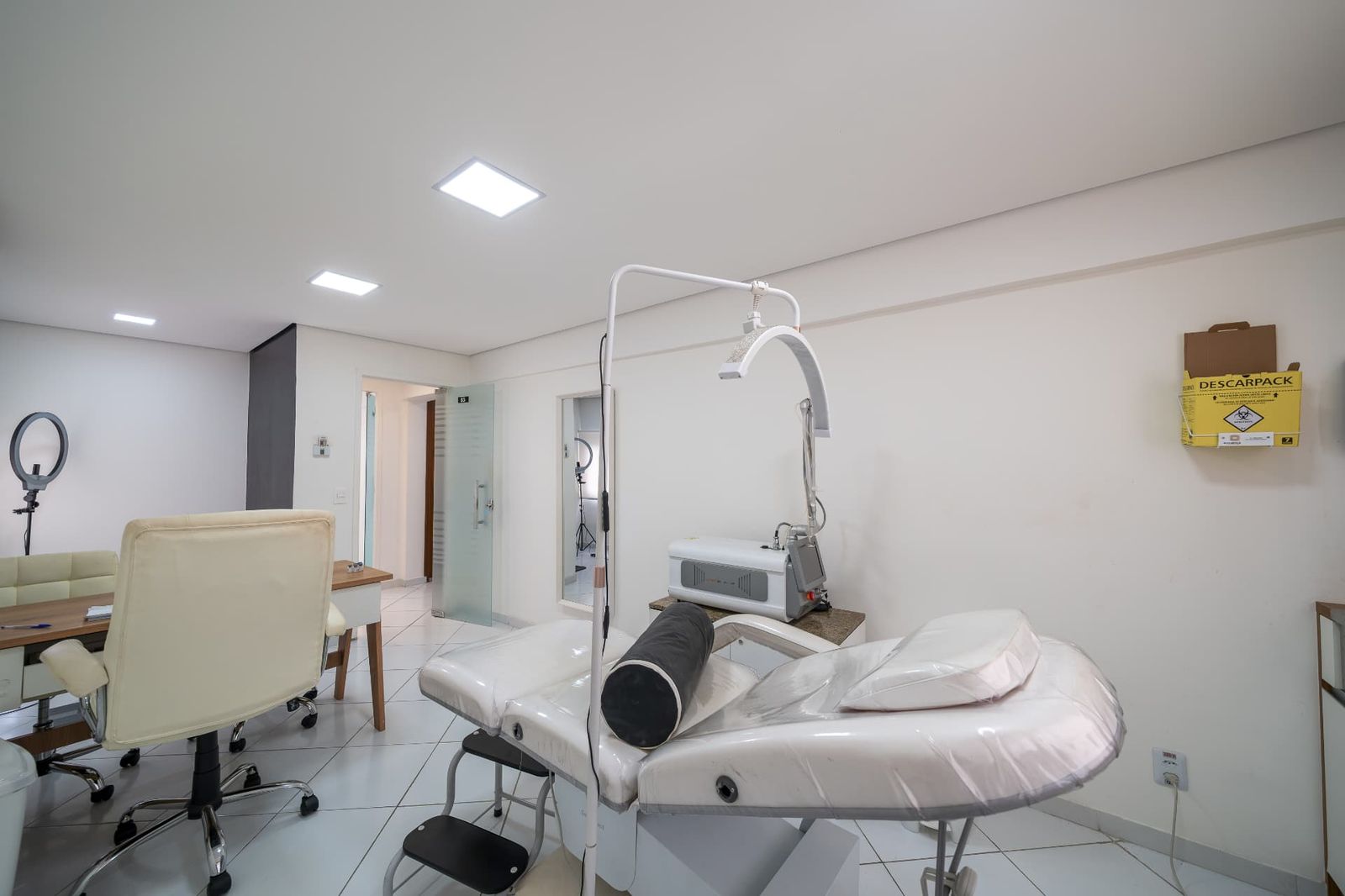 Sala com maca, foco cirúrgico e aparelho de laser