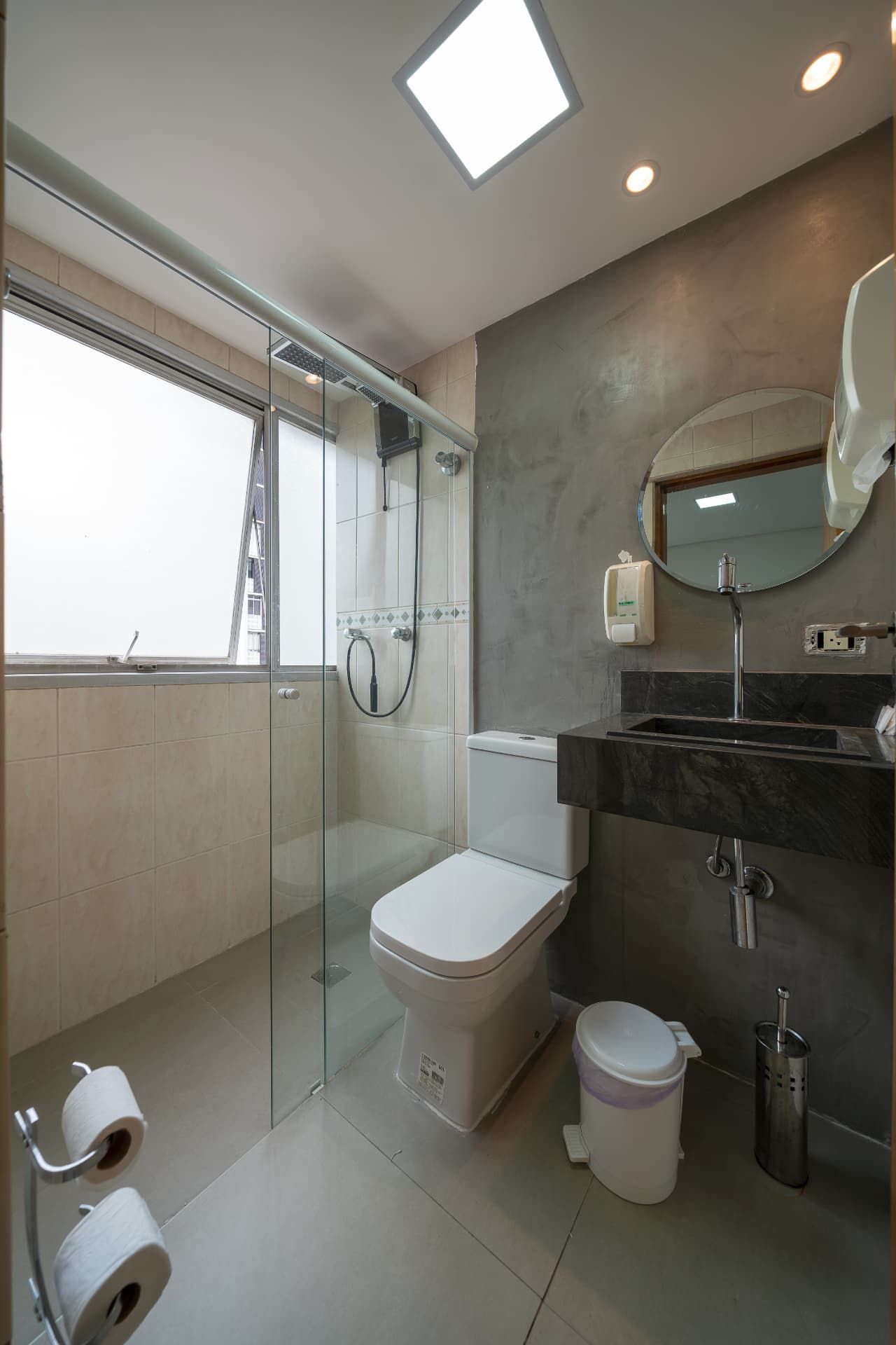 Banheiro com box, ducha, bancada em granito e espelho