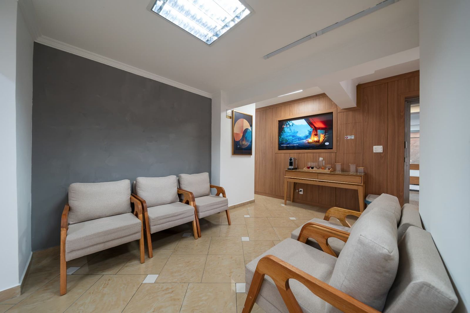 Sala de espera confortável com TV e cantinho do café